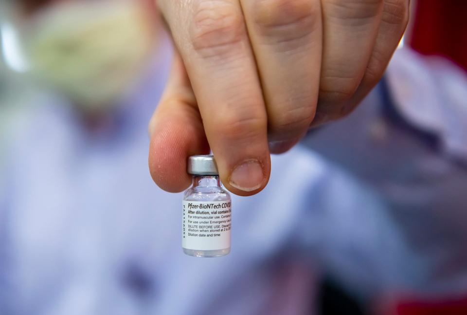 UPMC Jameson pharmacist Ronald Barnes of Sharpsville holds up a vial of the Pfizer vaccine before he puts it in needles for patients at the clinic.