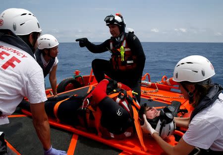 Rescue swimmers of the Migrant Offshore Aid Station (MOAS) and medical staff from Italian NGO EMERGENCY take part in a training exercise off the MOAS ship Topaz Responder, as the ship stands by for migrants in distress, in international waters off the coast of Libya, June 22, 2016. REUTERS/Darrin Zammit Lupi