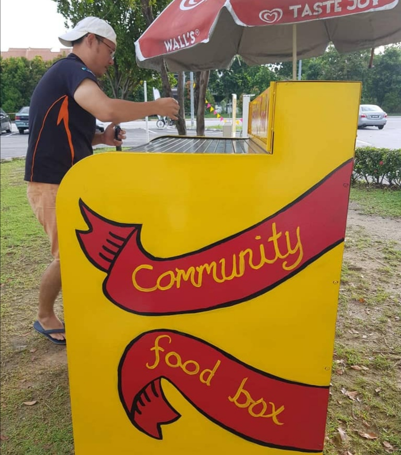 Volunteer Yap Chin Fei giving the community food box a fresh coat of paint. — Picture courtesy of Alfred Samuel Mariyaras