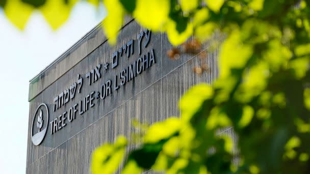 PHOTO: The signage on the dormant landmark Tree of Life synagogue in Pittsburgh's Squirrel Hill neighborhood is framed in spring foliage, Apr. 19, 2023.. (Gene J. Puskar/AP)