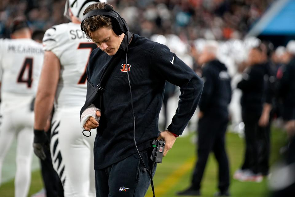 Cincinnati Bengals quarterback Joe Burrow (9) adjusts his headset while on the sideline after suffering a season-ending wrist injury in the first half of a Week 13 NFL football game against the Jacksonville Jaguars, Monday, Dec. 4, 2023, at EverBank Stadium in Jacksonville, Fla.