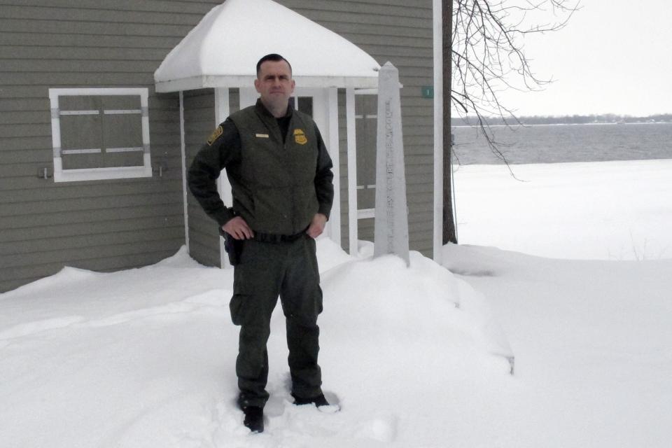 In this Monday Feb. 10, 2020, photo, U.S. Border Patrol Agent Dustin Judd poses near a border marker in Alburgh, Vt. Statistics show that the 295-mile Swanton Sector of upstate New York, Vermont and New Hampshire, sees the most illegal border crossing of any sector along the 4,000-mile U.S.-Canadian border. (AP Photo/Wilson Ring)