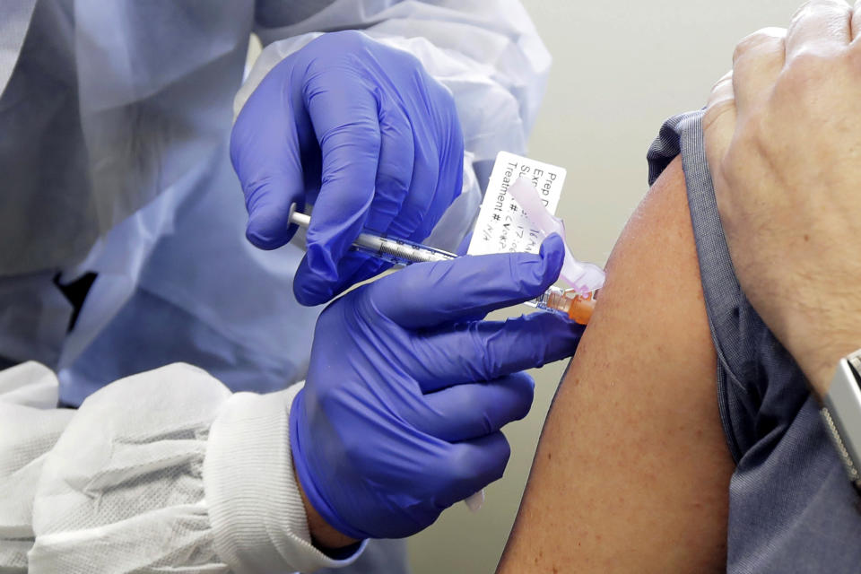 FILE - In this March 16, 2020, file photo, a patient receives a shot in the first-stage safety study clinical trial of a potential vaccine for COVID-19 at the Kaiser Permanente Washington Health Research Institute in Seattle. As the race for a vaccine against the new coronavirus intensifies, many rich countries are rushing to the front of the line by placing advance orders for the inevitably limited supply to guarantee their citizens are immunized first. (AP Photo/Ted S. Warren, File)