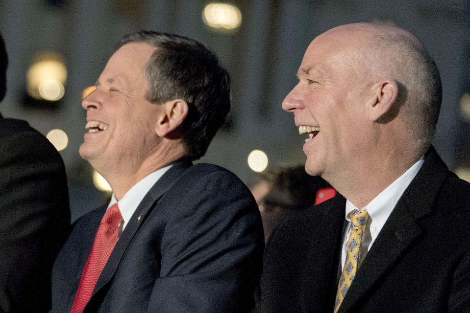 FILE - In this Dec. 6, 2017, file photo, Sen. Steve Daines, R-Mont., left, and Rep. Greg Gianforte, R-Mont., attend the 2017 Capitol Christmas Tree lighting ceremony on the West Lawn of the U.S. Capitol, in Washington. Since bonding on family camping trips more than two decades ago, Daines and Gianforte have worked in tandem, first to attain huge riches in the corporate world and more recently to leverage that success into a political juggernaut that's pushing Montana's Republican party further to the right. (AP Photo/Andrew Harnik, File)