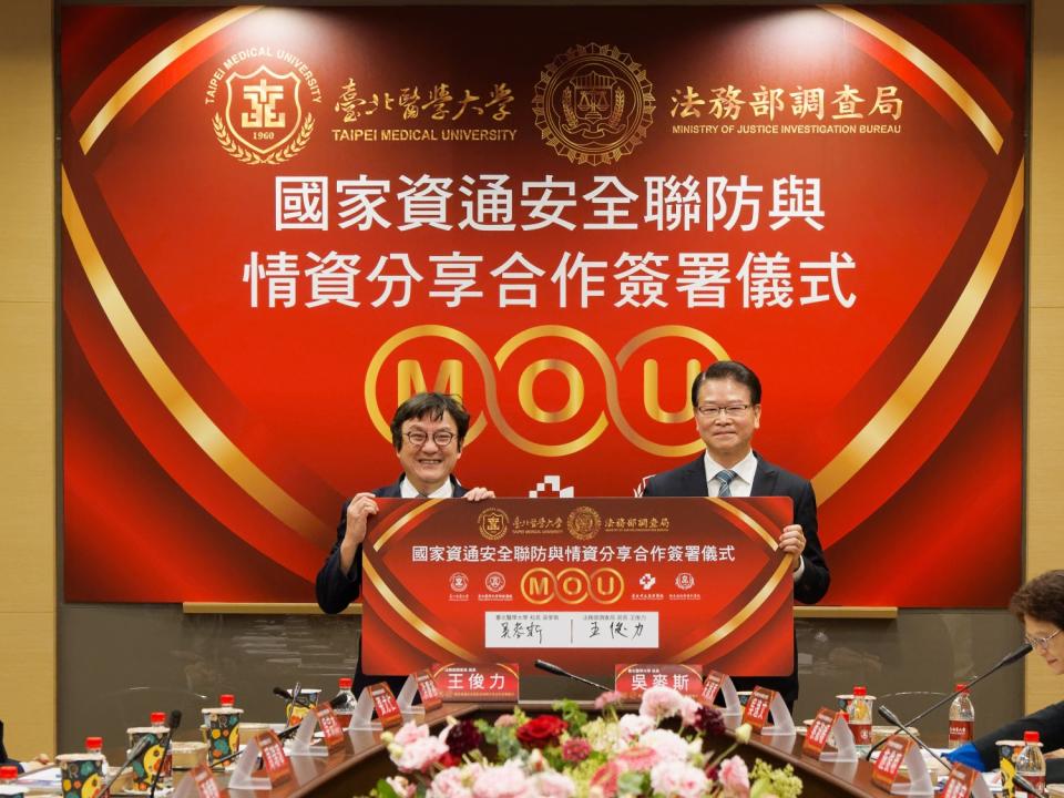 調查局局長王俊力(右)與台北醫學大學校長吳麥斯(左)簽署國家資通安全聯防與情資分享合作備忘錄。(記者張欽翻攝)
