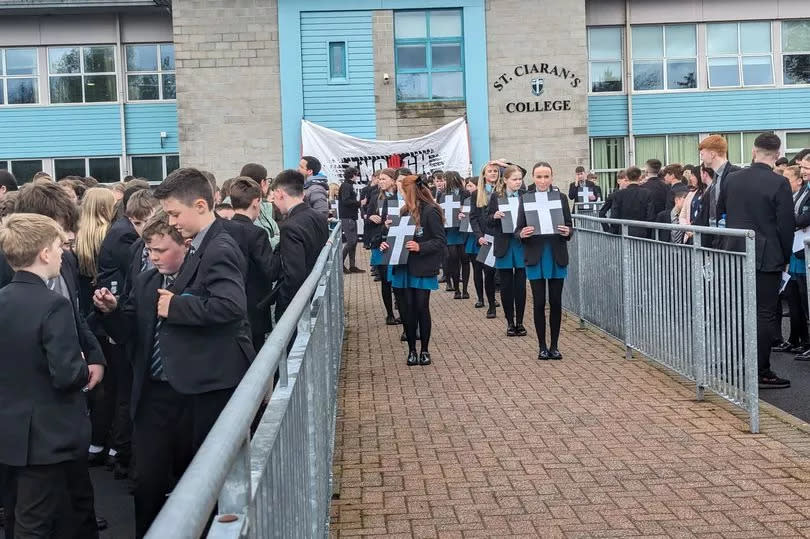 Pupils at St Ciaran's College hold crosses to remember those who have lost their lives on the A5