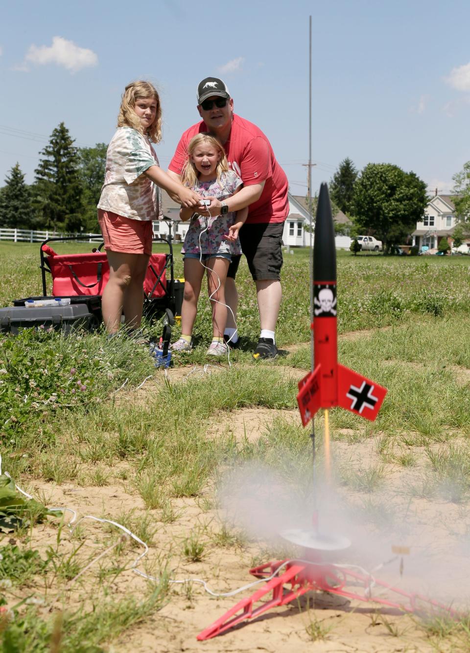 John Dean and his two daughters Avery, 10, and Savannah, 6, launch rockets they built on June 14, 2021. Taking up Dean's childhood hobby was one they spent time together during the pandemic.