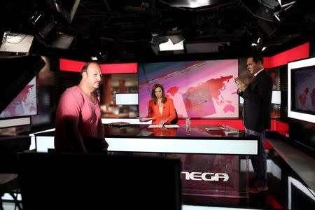 News anchor Maria Sarafoglou (C), journalist Dimitris Takis (R) and a cameraman are seen during an interval of a news broadcast at a studio of Greek private channel MEGA in Athens, Greece, August 30, 2016. REUTERS/Alkis Konstantinidis