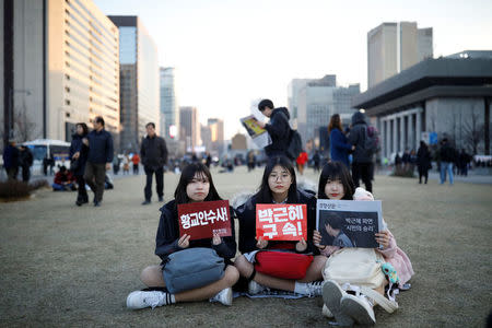 Students attend a rally calling for impeached President Park Geun-hye's arrest in central Seoul, South Korea, March 10, 2017. The headline of the newspaper reads "Expulsion of Park Geun-hye, People's victory". REUTERS/Kim Hong-Ji