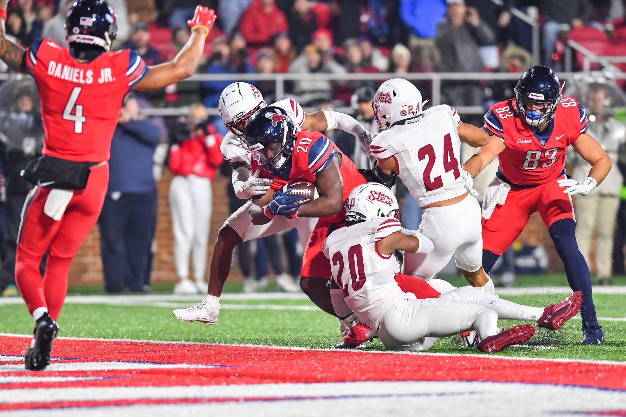 New Mexico State safety Mehki Miller (20) is in on the tackle vs. Liberty. Miller played the last two seasons for the Aggies and previously for the Miami RedHawks. He is now a UC Bearcat.