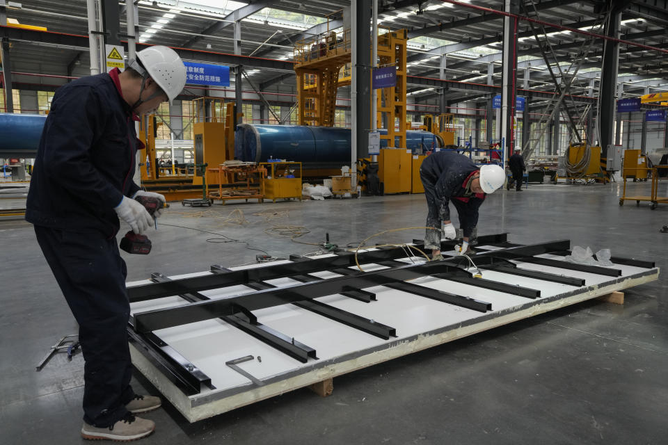 Workers assemble a chassis frame for the Dongfeng truck at a manufacturing factory in Shiyan city in central China's Hubei Province on May 12, 2023. China's factory activity decelerated in May, a survey showed Wednesday, May 31 adding to signs its economic rebound after the end of anti-virus controls is slowing. (AP Photo/Andy Wong)