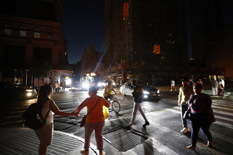 Pedestrians cross a dark street during a power outage, Saturday, July 13, 2019, in New York. (Photo: Michael Owens/AP)