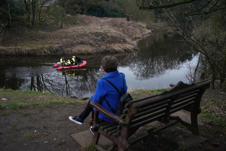 A woman sits on the bench by where Nicola Bulley’s belongings were found (PA)