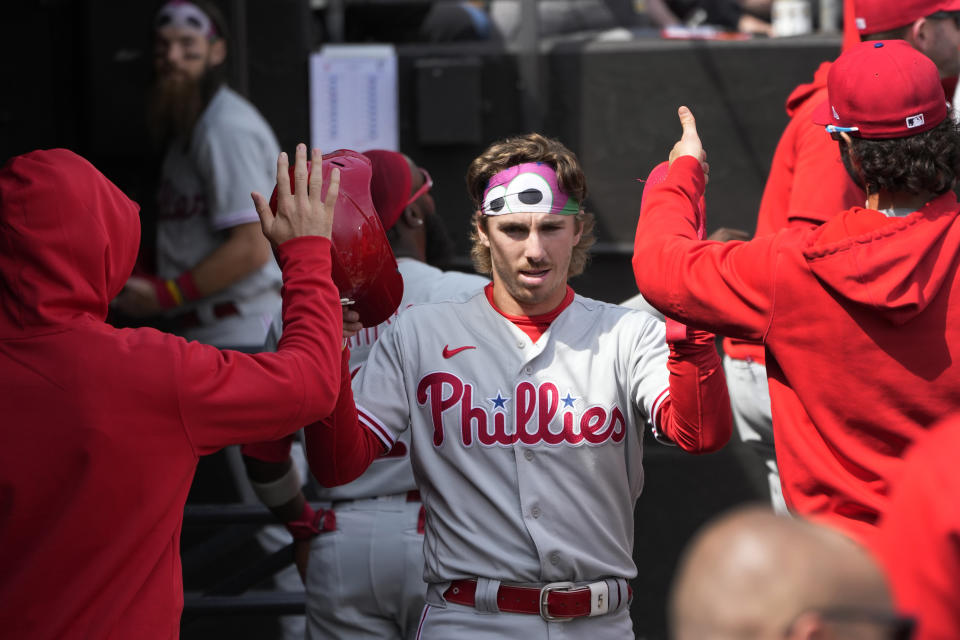 Philadelphia Phillies' Bryson Stott celebrates in the dugout after scoring on a double by Trea Turner during the fourth inning of a baseball game against the Chicago White Sox Wednesday, April 19, 2023, in Chicago. (AP Photo/Charles Rex Arbogast)