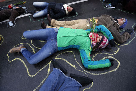 Demonstrators lay on the ground with chalk outlines representing a mock crime scene during a protest marking the 100th day since the shooting death of Michael Brown in St. Louis, Missouri November 16, 2014. REUTERS/Jim Young