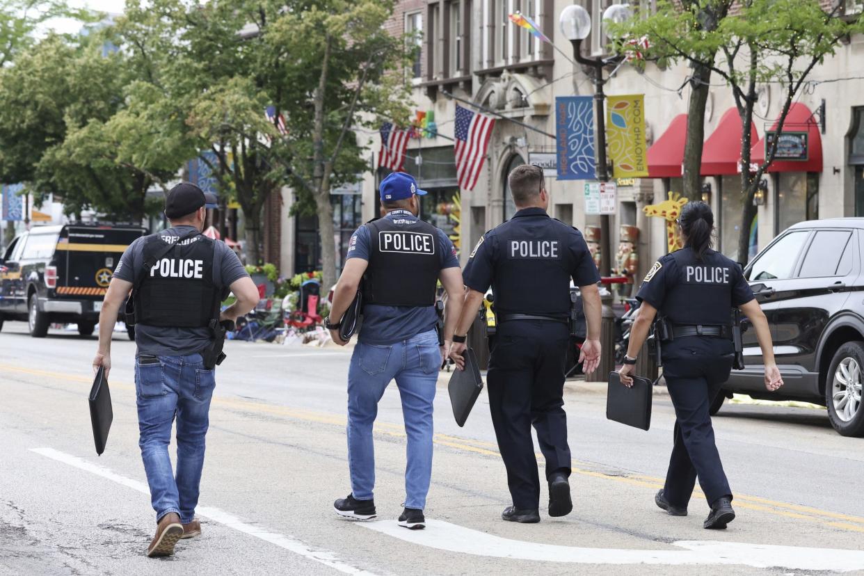 Law enforcement officials work the scene along the Highland Park Fourth of July parade route after people fled the scene on Monday, July 4, 2022.