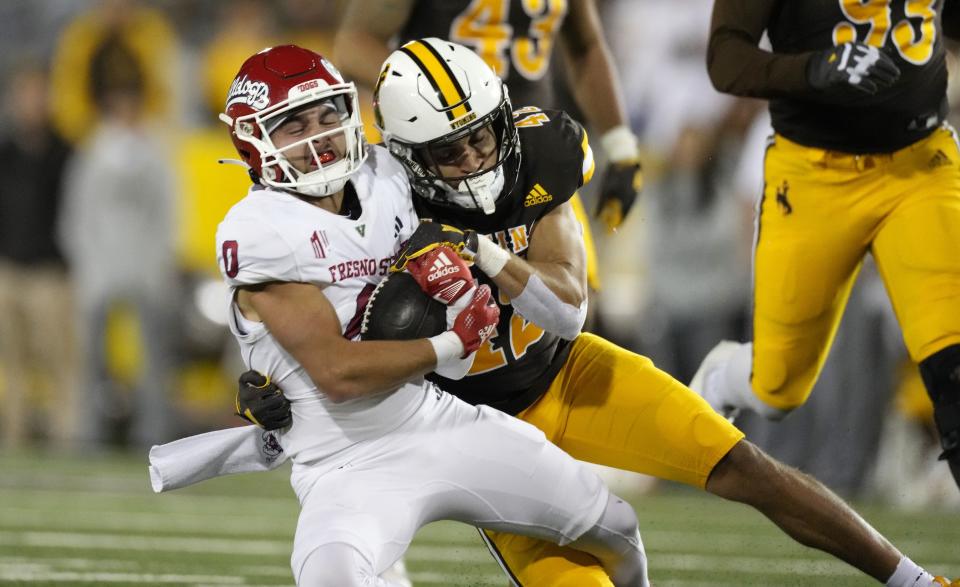 Fresno State wide receiver Mac Dalena (0) is pulled down after catching a pass by Wyoming safety Isaac White (42) in an NCAA college football game Saturday, Oct. 7, 2023, in Laramie, Wyo. | David Zalubowski, Associated Press