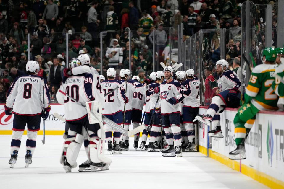 Columbus Blue Jackets celebrate after an overtime win over the Minnesota Wild in an NHL hockey game Saturday, Oct. 21, 2023, in St. Paul, Minn. (AP Photo/Abbie Parr)