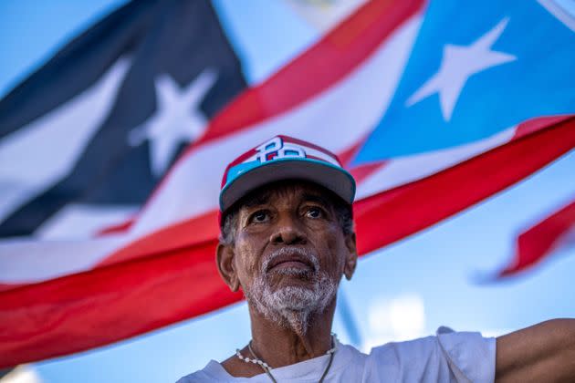 A protester stands outside the headquarters of LUMA Energy, the company that took over the transmission and distribution of Puerto Rico's electric authority, after a blackout hit the island in April. (Photo: RICARDO ARDUENGO via Getty Images)