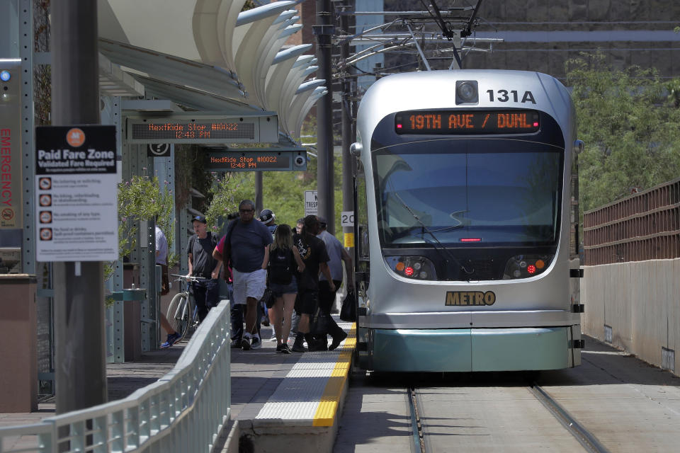 A light rail train stops for passengers, Monday, Aug. 26, 2019 in Tempe, Ariz. The latest numbers on mail-in ballots are expected Monday after the weekend for Tuesday's special election weighing any future expansion to the light rail system in Phoenix, the nation's fifth largest city. (AP Photo/Matt York)