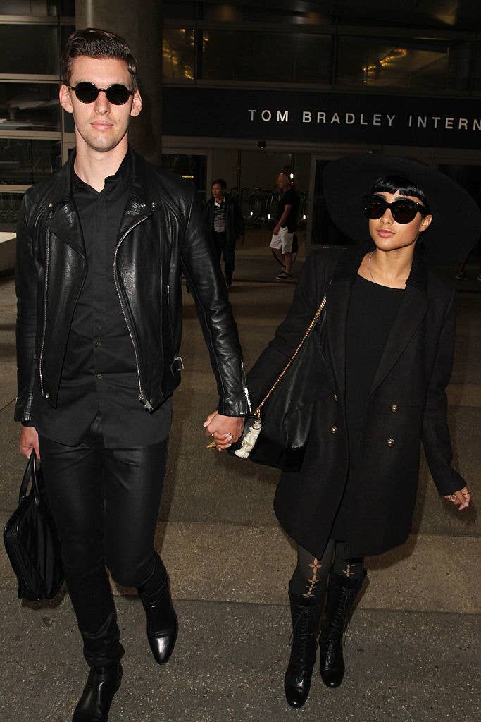 the two holding hands as they leave the airport