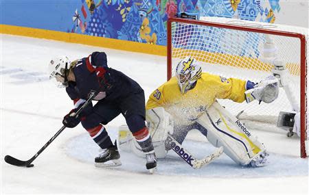 Team USA's Jocelyne Lamoureux (L) tries to spin around and score on a penalty shot against Sweden's goalie Kim Martin Hasson during the third period of their women's semi-final ice hockey game at the 2014 Sochi Winter Olympics, February 17, 2014. REUTERS/Grigory Dukor