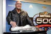 Grand Marshal Dwayne "The Rock" Johnson poses with the Harley J. Earl trophy after the NASCAR Daytona 500 auto race was postponed by rain Sunday, Feb. 18, 2024, at Daytona International Speedway in Daytona Beach, Fla. (AP Photo/Terry Renna)