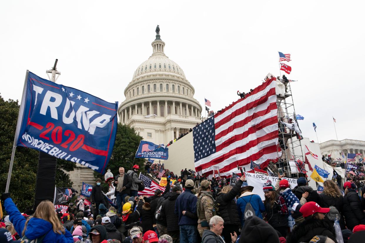 FILE - Violent insurrectionists loyal to President Donald Trump stand outside the U.S. Capitol in Washington on Jan. 6, 2021. 