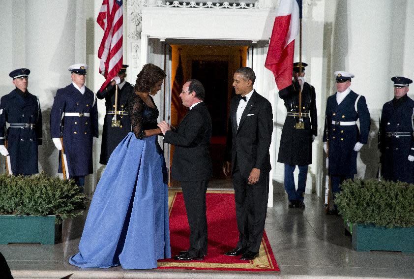 First lady Michelle Obama, left, and President Barack Obama welcome French President Francois Hollande for a State Dinner at the North Portico of the White House on Tuesday, Feb. 11, 2014, in Washington. (AP Photo/ Evan Vucci)