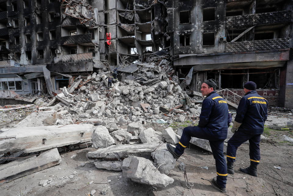 Emergency workers remove debris of a building destroyed in the course of the Ukraine-Russia conflict, in the southern port city of Mariupol, Ukraine April 10, 2022. REUTERS/Alexander Ermochenko