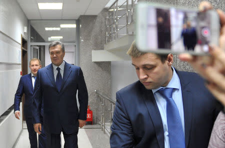 Ukraine's former President Viktor Yanukovich walks towards the media after a video link with a Ukrainian court during the trial of former riot police force members, suspected of killing participants of the 2014 anti-government and pro-European Union mass protests, inside a building of a regional court in Rostov-on-Don, Russia, November 25, 2016. REUTERS/Stringer