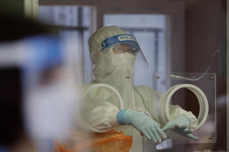 A medical worker wearing protective gear prepares to take a sample at a temporary screening clinic for coronavirus in Seoul, South Korea, Saturday, April 10, 2021. (AP Photo/Lee Jin-man)