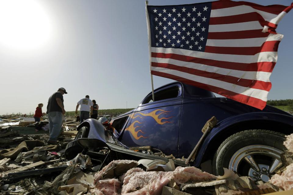 Friends and family sift through debris at the home of Daniel Wassom after is was destroyed by a tornado, Monday, April 28, 2014, in Vilonia, Ark. Wassom died in the tornado trying to shield a family member. (AP Photo/Eric Gay)