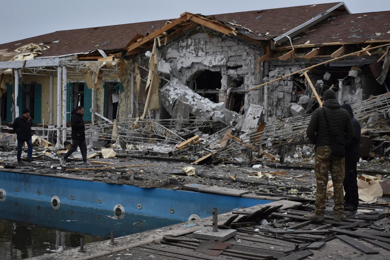 People inspect a damaged restaurant after Russian shelling hit in Zaporizhzhia, Ukraine on Saturday, 18 March (The Associated Press)