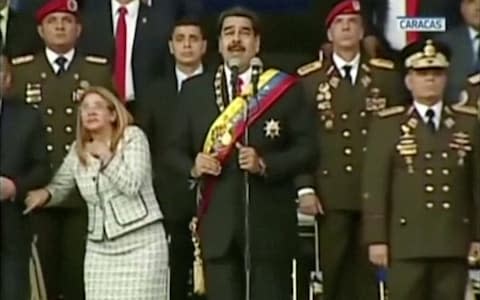 Venezuelan President Nicolas Maduro and his wife react in this still frame taken from video - Credit: Reuters