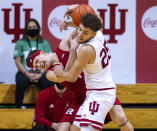 Rutgers guard Paul Mulcahy, left, and Indiana forward Race Thompson, right, battle for a rebound during the second half of an NCAA college basketball game, Sunday, Jan. 24, 2021, in Bloomington, Ind. (AP Photo/Doug McSchooler)