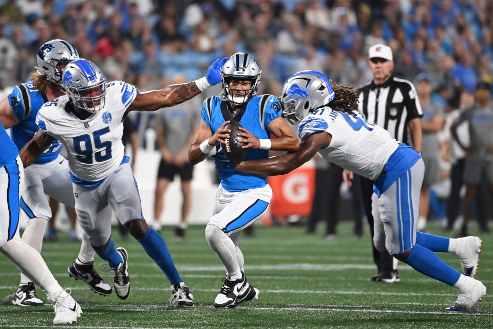 Carolina Panthers quarterback Bryce Young is sacked by Detroit Lions linebacker James Houston (41) as defensive end Romeo Okwara (95) helps defend in the first quarter of a preseason game at Bank of America Stadium, Aug. 25, 2023.