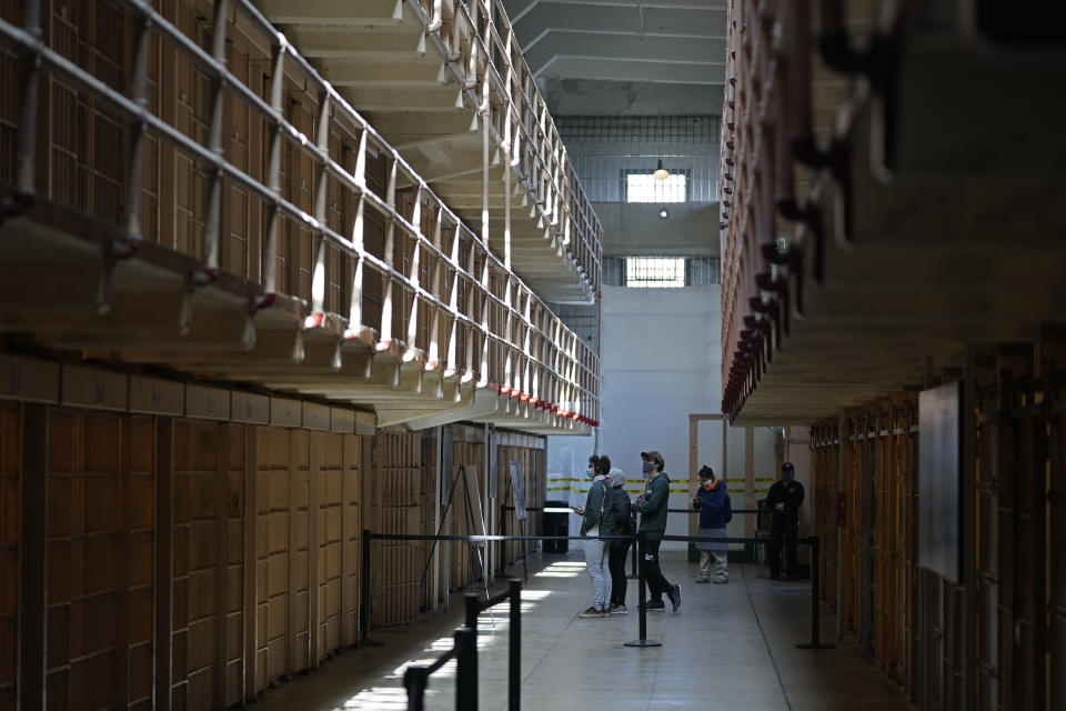 People tour the main cell house on Alcatraz Island in San Francisco, Monday, March 15, 2021. The historic island prison was reopened to visitors Monday after being closed since December because of the coronavirus threat. Visitors were also able to tour the inside of the main cell house for the first time in a year. (AP Photo/Eric Risberg)