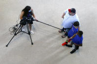 A member of the media uses a long microphone boom to interview Texas Rangers baseball fans during the first day of public tours at Globe Life Field, home of the Texas Rangers baseball team, in Arlington, Texas, Monday, June 1, 2020. The coronavirus pandemic has forced sports teams and their leagues to evaluate how they will welcome back fans. (AP Photo/LM Otero)