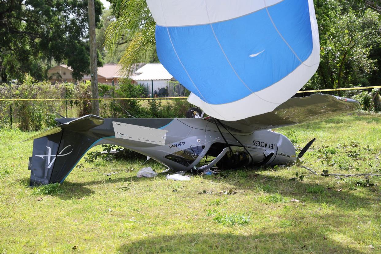 A plane, with parachute deployed, crashed in a yard in Seffner, Florida Thursday, April 4, 2024.