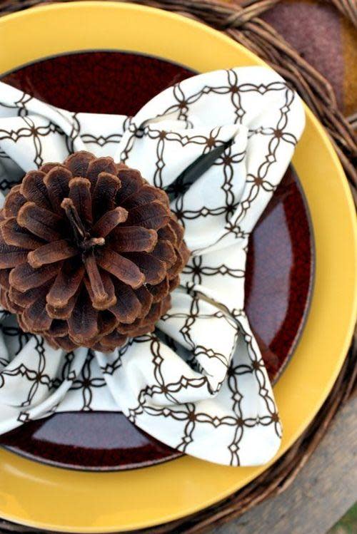 napkin folded in to pinecone shape accented with yellow