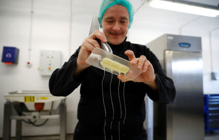 Nestle's Jan Kuendiger removes excess white chocolate from a mould in a kitchen at the company's Product Technology Centre in York, Britain, March 21, 2018. Picture taken March 21, 2018. REUTERS/Phil Noble