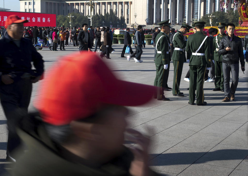 Visitors walk past as Chinese paramilitary policemen prepare for their duty at Tiananmen Square in Beijing Thursday, Nov. 1, 2012. Beijing is tightening security as its all-important Communist Party congress approaches, and some of the measures seem bizarre. Most of the security measures were implemented in time for Thursday's opening of a meeting of the Central Committee. (AP Photo/Andy Wong)