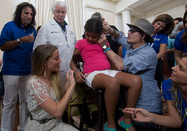 Giving back can sometimes be emotional. Amber Heard accompanied her husband, Johnny Depp, in Brazil on Thursday, where the couple partnered with the Starkey Hearing Foundation to help distribute hundreds of hearing aids to those in need. The experience was clearly a profound one for the 29-year-old actress, who was brought to tears as one woman received the life-changing gift. AP Images <strong>WATCH: EXCLUSIVE -- Amber Heard Rocks Tiny White Bikini on Brazilian Vacation With Johnny Depp</strong> AP Images "The reaction somebody has when they hear for the first time, in this case, you see it light up -- changes their whole face," Heard told the <em>Associated Press</em>. "Just to be a small part of that for one moment, to watch someone's life change in front of you, it's moving to say the least." Depp, 52, was touched by the moment as well. AP Images "If you pass something over to someone that they haven't had ever before, it's very moving," the <em>Black Mass</em> star explained. "This sweet little girl, I turned the volume up and I just sort of made a noise – ‘ba-ba-ba-ba-ba’ -- and she went, 'Yes! Escuchar, I can hear!'" Depp was actually in Brazil to perform with his star-studded band, Hollywood Vampires -- which includes Alice Cooper and Aerosmith's Joe Perry -- at the Rock in Rio music festival in Rio de Janeiro. Cooper was also present at the event which took place earlier in the day, helping to hand out hearing aids. <strong>WATCH: Johnny Depp Responds to Australia Dog Smuggling Drama -- 'I'll Assault That Man If They Send My Wife to Jail'</strong> Last week, ETonline caught Heard rocking out to the Hollywood Vampires' concert at the Roxy Theater in West Hollywood, California. The beautiful blonde, who's been married to Depp since February, appeared to be quite the supportive wife. "From where I was standing, Amber was totally beaming as she watched Johnny," ETonline's Denny Directo said. "She was sipping red wine, bopping around to the music. By the end of the show, she was on her feet." Watch below!
