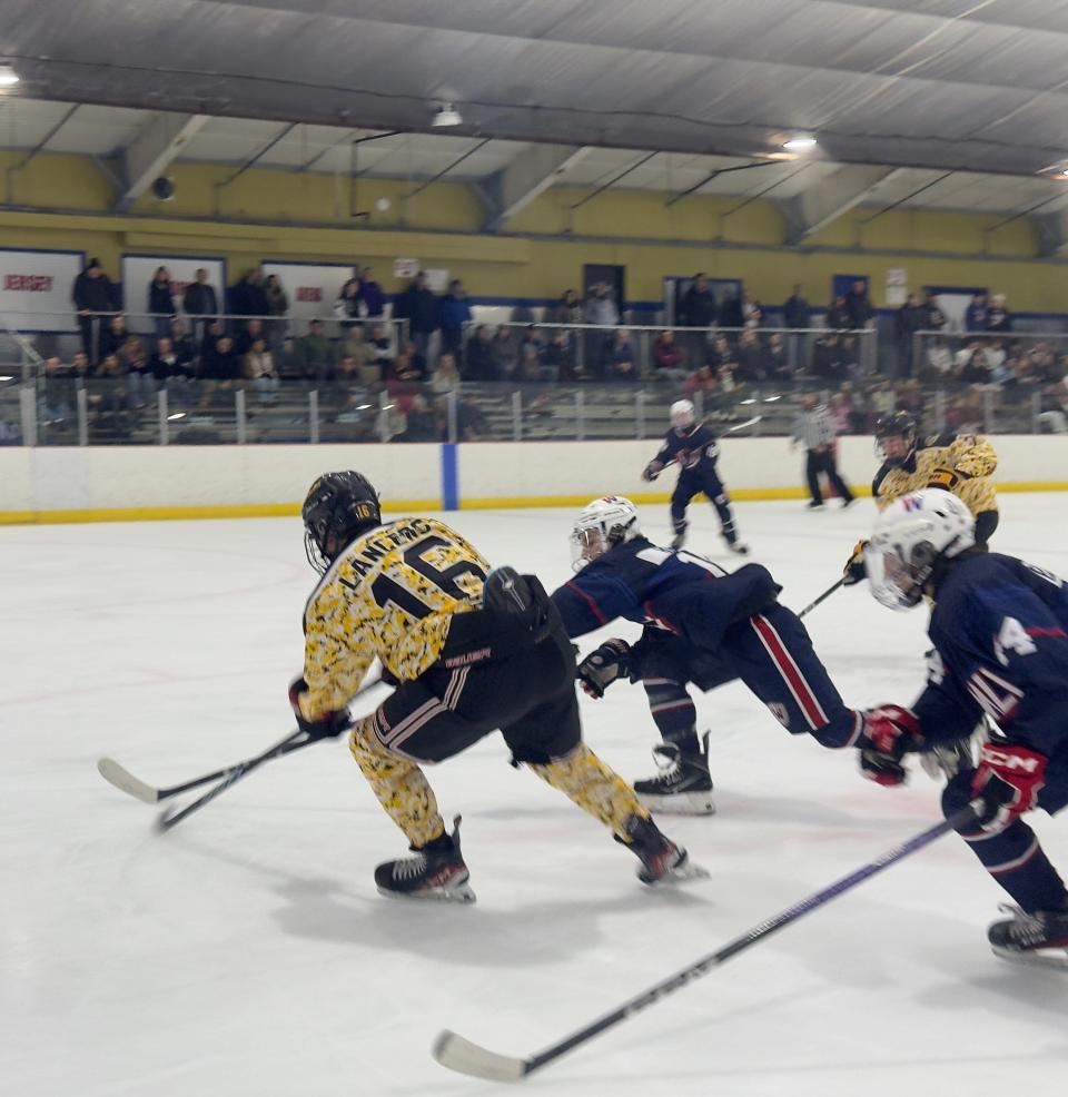 St. John Vianney junior Nick Kasich holds off Wall defenders in the first period.