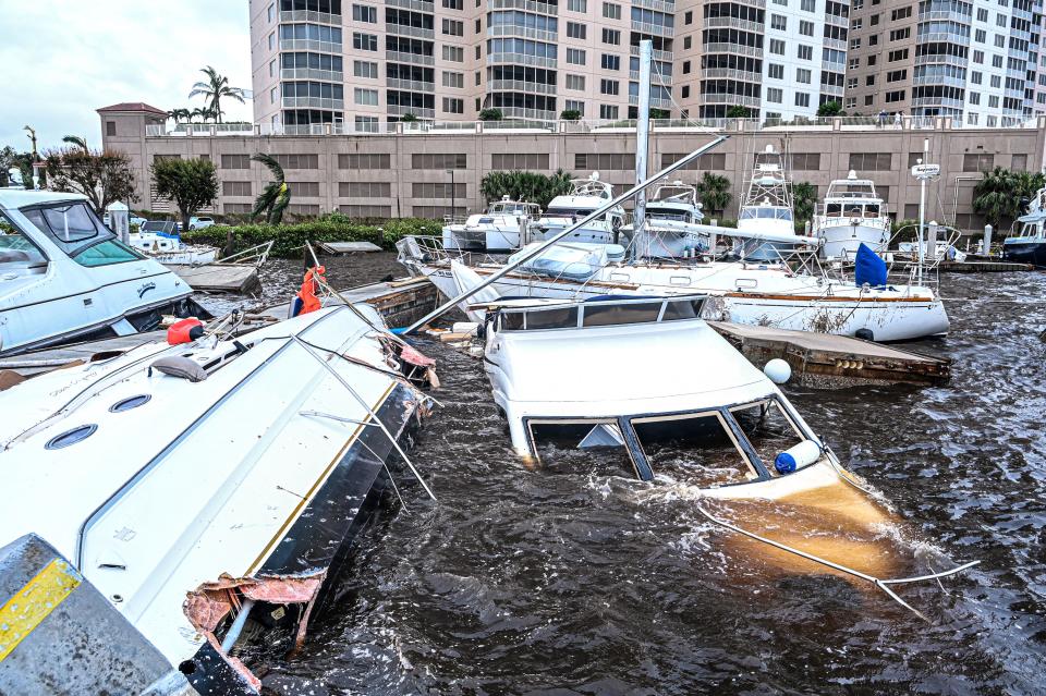 Boat are partially submerged at a marina in the aftermath of Hurricane Ian in Fort Myers, Florida, on September 29, 2022. - Hurricane Ian left much of coastal southwest Florida in darkness early on Thursday, bringing 