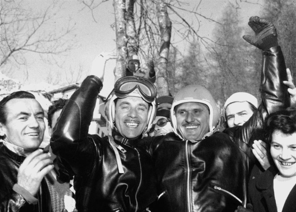 FILE - In this Jan. 28, 1956 file photo, Italy's Giacomo Conti, right, brakeman, and driver Lamberto Dalla Costa, smile and wave after winning the two-man bobsled championship of the Winter Olympics at Cortina D'Ampezzo, Italy. The Cortina track was built in 1923 and the resort known as the “Queen” of the Italian Dolomites was home to bobsledding great Eugenio Monti, who won six Olympic medals between 1956 and 1968. (AP Photo, File)