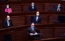 Erick Tsang, front, Hong Kong's secretary for Constitutional and Mainland Affairs, speaks at the first and second reading of "Improving Electoral System (Consolidated Amendments) Bill 2021" at the Legislative Council in Hong Kong, Wednesday, April 14, 2021. Hong Kong’s electoral reform bill was introduced in the city’s legislature on Wednesday, setting in motion changes that will give Beijing greater control over the process while reducing the number of directly elected representatives. (AP Photo/Vincent Yu)