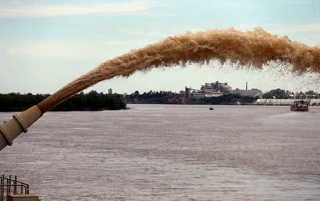 FILE PHOTO: A dredging boat sprays sand at the shore on the Parana river near Rosario, Argentina
