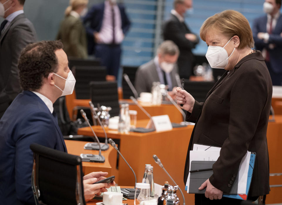 German Chancellor Angela Merkel, right, talks to German Health Minister Jens Spahn, as she arrives for the weeekly cabinet meeting at the Chancellery in Berlin, Germany, Wednesday, Feb. 24, 2021. (Kay Nietfeld/dpa via AP, Pool)